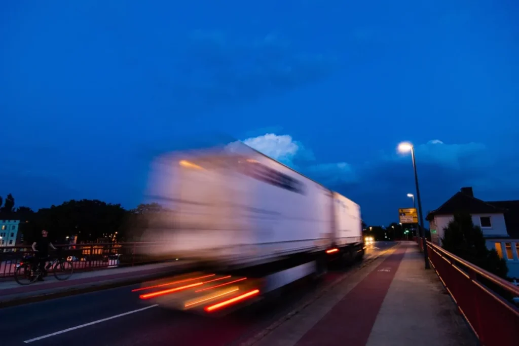 Camion lourd qui roule à la tombée de la nuit – heures de conduite et de repos
